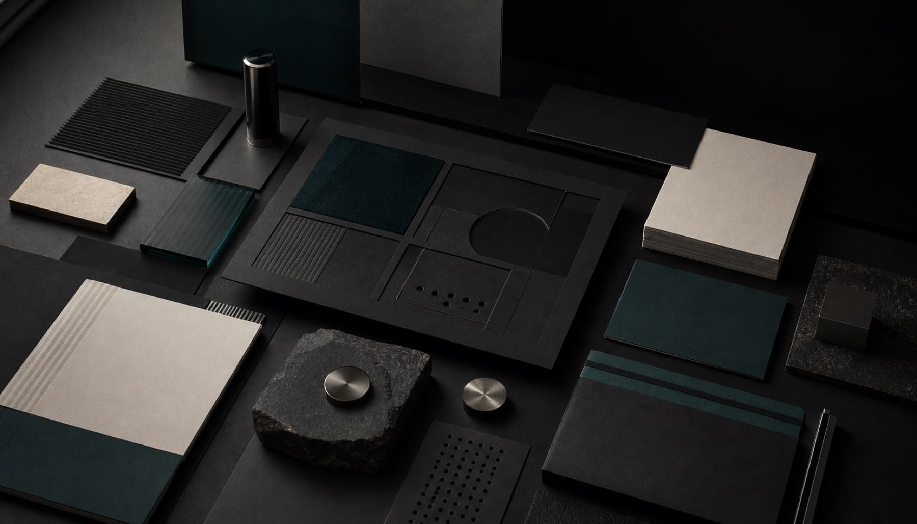 A dark tabletop arranged with modular brand materials
